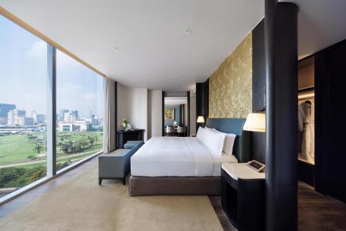 a hotel room with a bed and a large window at Waldorf Astoria Bangkok in Bangkok