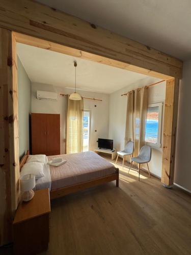 a bedroom with a bed and a table and chairs at Molos Beach Rooms in Kissamos