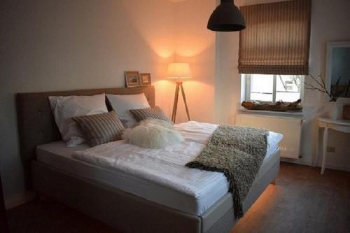 a bedroom with a bed with a lamp and a window at Stadtapartement Geisa in Geisa