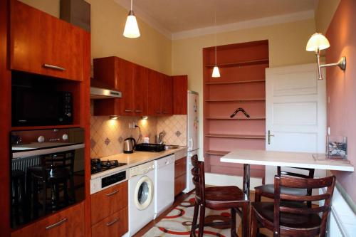 a kitchen with wooden cabinets and a table with chairs at Apartm&aacute;n Moyzesova in Ko&scaron;ice