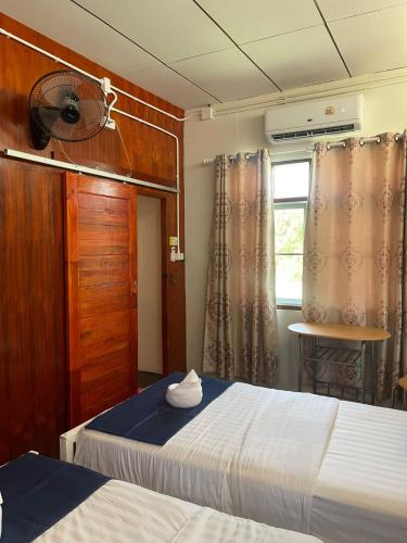 a bedroom with two beds and a window at Ladybugs hostel sunset in Taling Ngam Beach