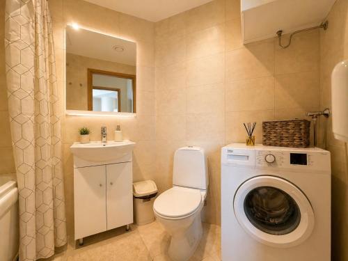 a bathroom with a washing machine and a sink at Panoramic Sea View -11th Floor in Tallinn
