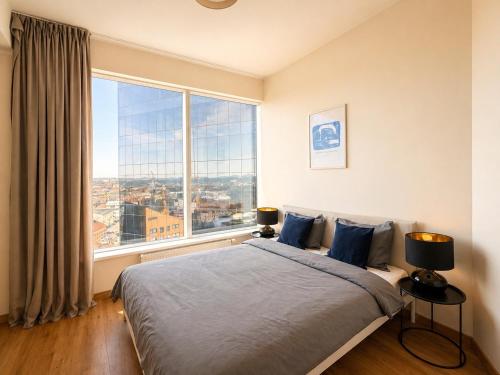 a bedroom with a bed and a large window at Panoramic Sea View -11th Floor in Tallinn