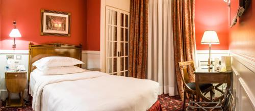 a red bedroom with a bed and a desk and a chair at Grand Hotel Sitea in Turin