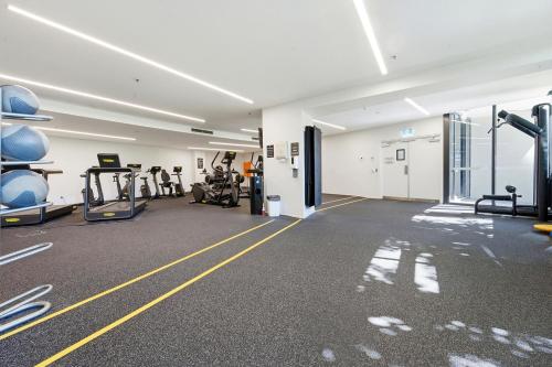 a gym with treadmills and machines in a room at Stylish 1-Bed in CBD with Secure Underground Parking in Canberra