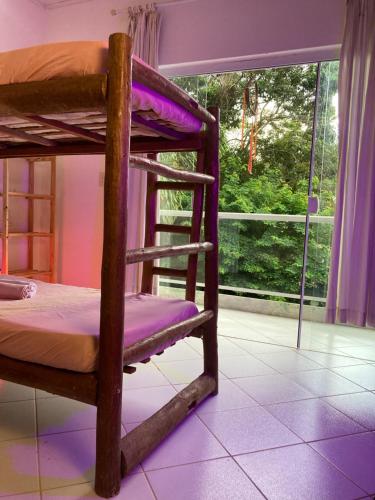 a couple of bunk beds in a room with a window at Covil das Trilhas Coliving SÓ PARA MULHERES in Lençóis