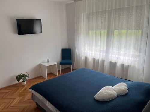 a bedroom with a bed with two stuffed animals on it at Stan na dan Vrdnik in Vrdnik