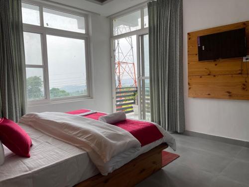 a bedroom with a bed and a large window at BlueWave Villa in Kangra