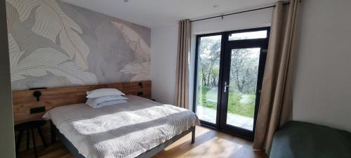a bedroom with a bed and a sliding glass door at Bran Villa - A-frame Orchard Hygge in Bran