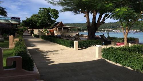 a walkway next to a lake with a building at Mama Beach Residence - Adults Only in Phi Phi Don