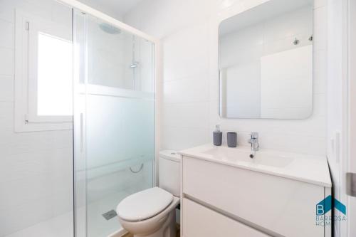 a white bathroom with a toilet and a sink at Ginebra B BARROSAHOME in Novo Sancti Petri