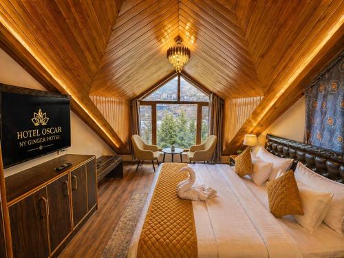 a bedroom with a large bed and a tv in a room at Hotel Oscar By Ginger Hotels Chain Near Club House Road Manali Luxury Rooms Best Hotel In Manali !!!!! in Manāli