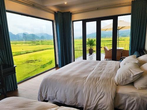 a bedroom with a bed and a large window at Karst Residence Phong Nha in Phong Nha