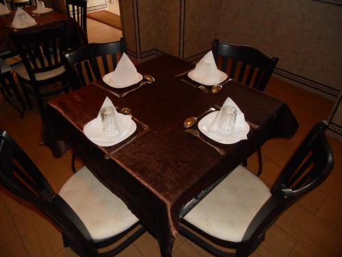 a wooden table with plates and napkins on it at Hotel Salama STE SAL- AMA SUD SARL AU in Tafraout