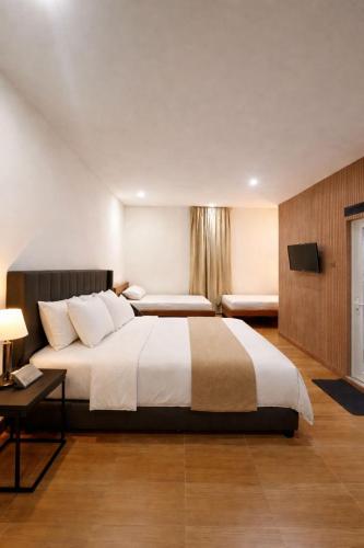 a hotel room with a large bed and a table at Jon's Paradise Villa and Resto in Sajang