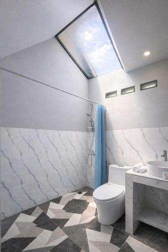 a bathroom with a toilet and a sink and a window at Jon's Paradise Villa and Resto in Sajang