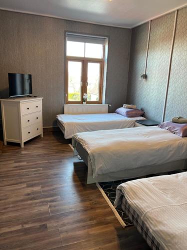 a room with four beds and a tv and a window at Rüütli kodumajutus in Paide