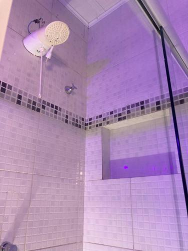 a shower with purple tiles in a bathroom at Covil das Trilhas Coliving SÓ PARA MULHERES in Lençóis