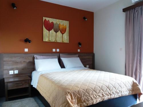 um quarto com uma cama e um quadro de tulipas em Ξενοδοχείο Αφροδίτη- Hotel Aphrodite em Lepanto