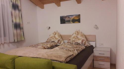 Bett in einem Zimmer mit grüner Couch in der Unterkunft Chalet Sunnseitn in Radstadt