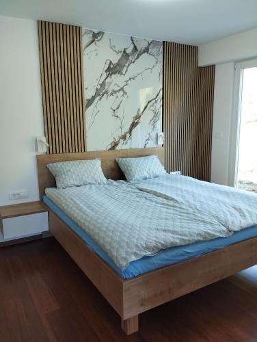 a bedroom with a bed with a large painting on the wall at POČITNIŠKA HIŠA Jan in Mišji Dol
