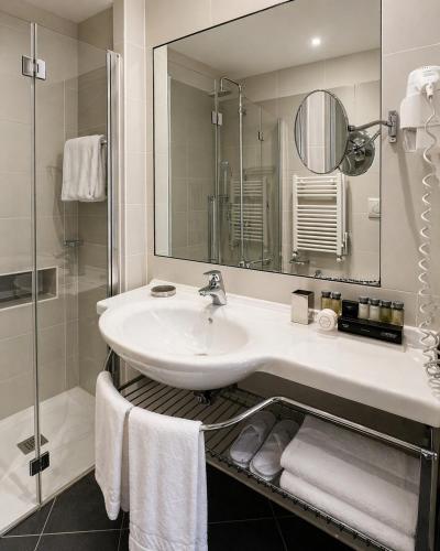 a bathroom with a sink and a mirror and towels at BB Hotels Smarthotel Missori in Milan