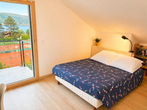 a bedroom with a bed and a large window at L 'Écrin du Lac et Parkings in Veyrier-du-Lac