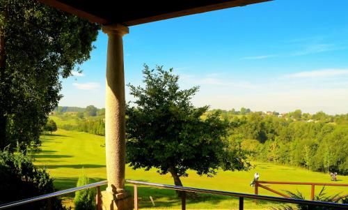 a view of a golf course from a porch at Oca Palacio De La Llorea Hotel & Spa in Deva