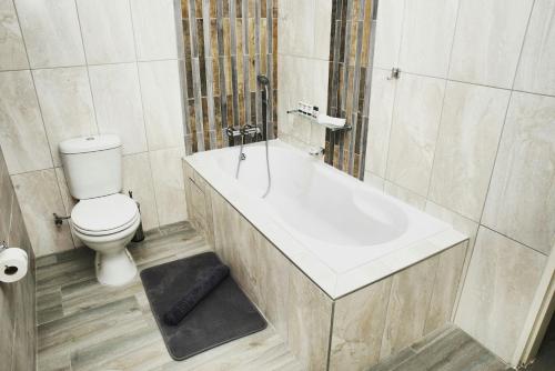 a bathroom with a toilet and a bath tub at Q's Boutique Stay in Standerton
