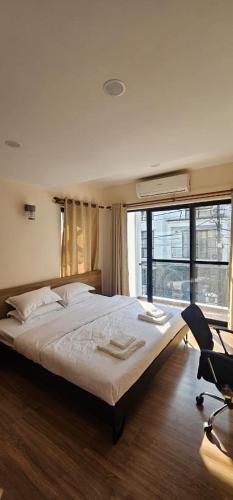 a bedroom with a bed and a chair and a window at Samaya Private Home Panipokhari - 5BHK in Thapathali