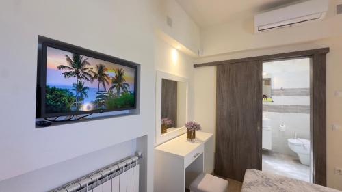 a bathroom with a television hanging on a wall at Modern Cycladic Sea View House in Ornos
