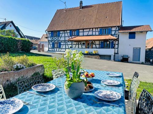 a table with plates of food and a house in the background at La Maison Schmoutz in Forstheim