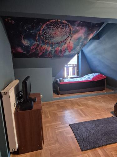 a room with a bed and a painting on the ceiling at Endurance in Krośnica