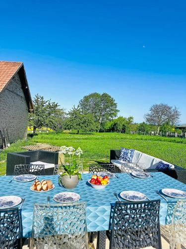 a blue table with chairs and food on it at La Maison Schmoutz in Forstheim