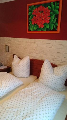 two beds with white pillows and a painting on the wall at Landgasthof zum Hirschenstein, Pension Garni in Sankt Englmar