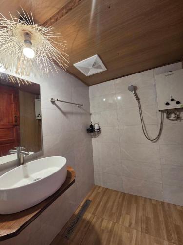 a bathroom with a white sink and a mirror at Motho Homestay โมโทโฮมสเตย์ in Chom Thong
