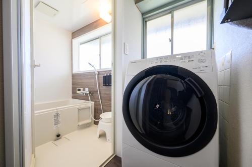 a washing machine in a bathroom with a toilet at 糸島 古雅 Koga in Itoshima