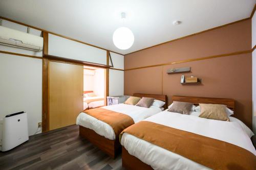 a hotel room with two beds and a television at 糸島 古雅 Koga in Itoshima