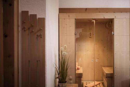 ein Zimmer mit Holztüren und einer Topfpflanze in der Unterkunft Aussermahrhof - familyfarm in Gsies