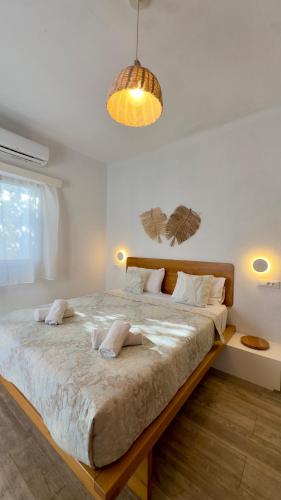 a white bedroom with a large bed with two pillows at Modern Cycladic Sea View House in Ornos