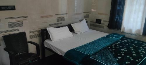 a small bedroom with a bed and a window at Cmt Lodge & Rooms in Mysore