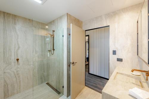 a bathroom with a shower and a glass door at BIG4 Sandstone Point Holiday Resort Bribie Island in Bongaree