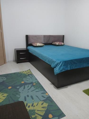 a bedroom with a bed with blue sheets and a rug at Apart hotel Sara seaview in Olimp