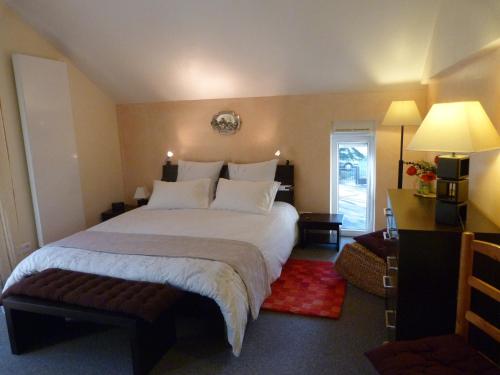1 dormitorio con 1 cama blanca grande y escritorio en Gîte d'Maïsala Les Mésanges en Heidwiller