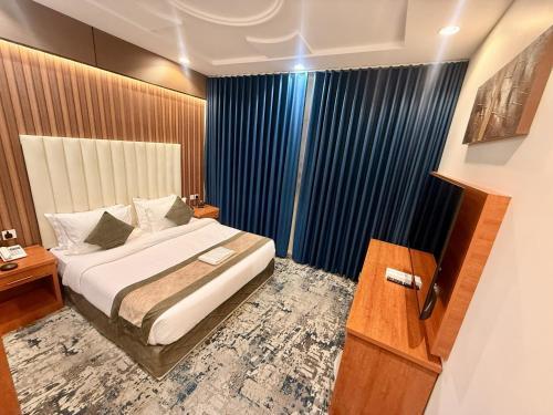 a bedroom with a bed and a large window at Milestone Rise Jeddah in Jeddah