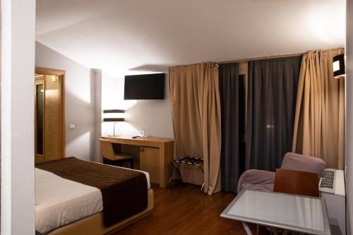 a hotel room with a bed and a desk and a chair at Regal Hotel in Brescia