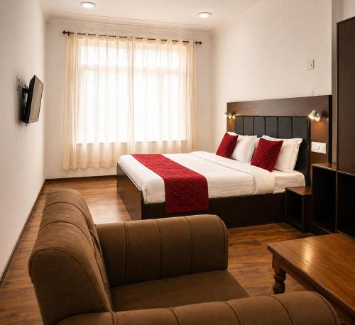 a hotel room with a bed and a couch at The Ladakh Residency Kargil in Kargil