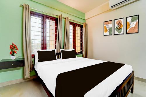 a bedroom with a large bed in front of a window at Collection O Kottayam Formerly Sap Inn in Kottayam