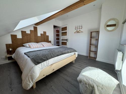 a bedroom with a large bed with a wooden headboard at L'ANTRE Deux LACS avec parking et garage in Xonrupt-Longemer