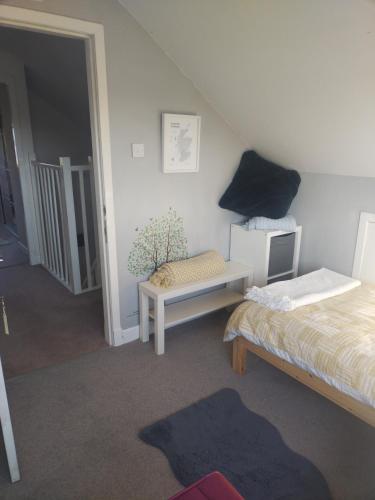 a bedroom with a bed and a table and a chair at Rooms by the Lade Braes & Doocot in St Andrews in St. Andrews